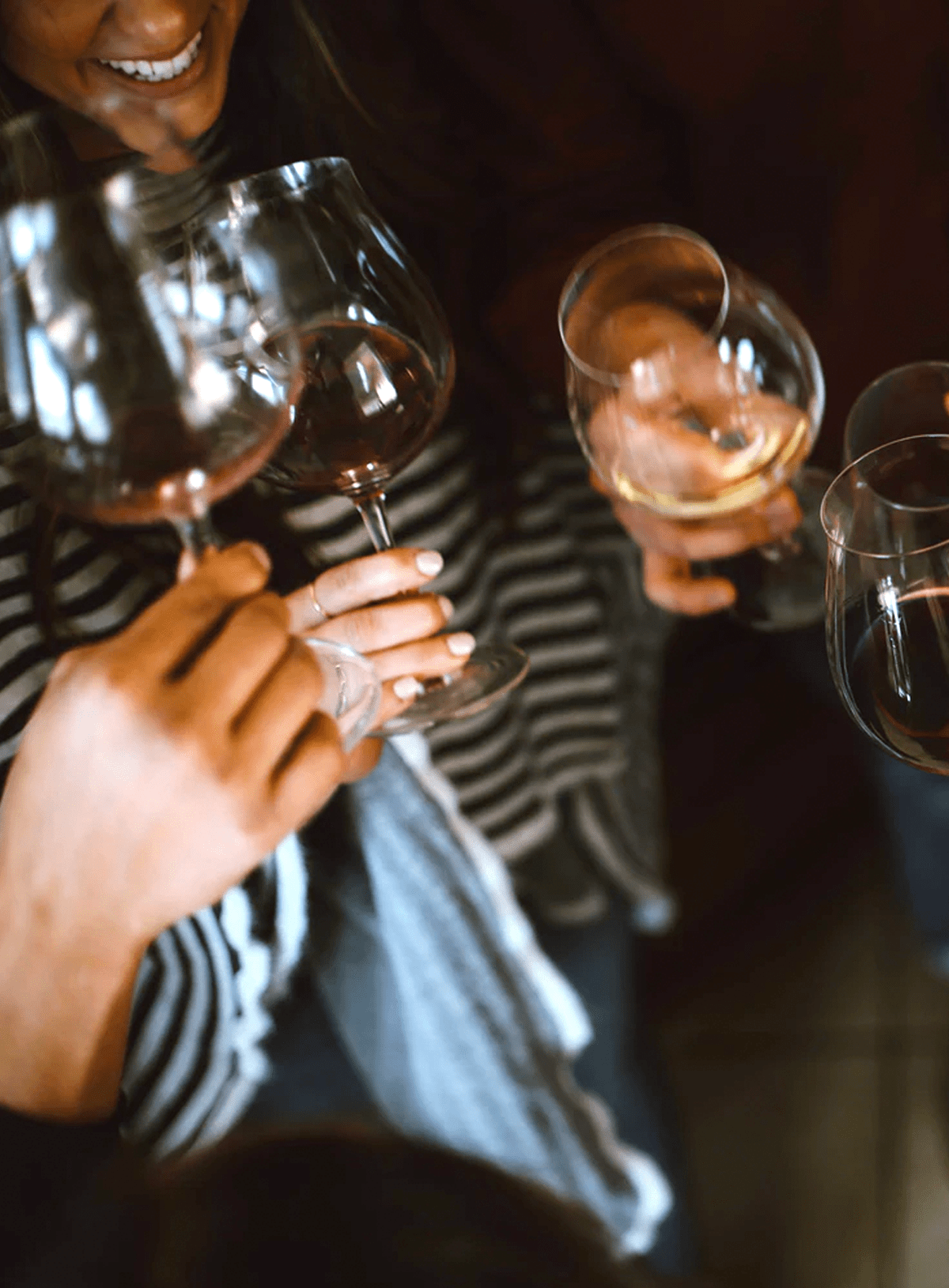 moody image of friends enjoying a glass of wine during a dinner gathering