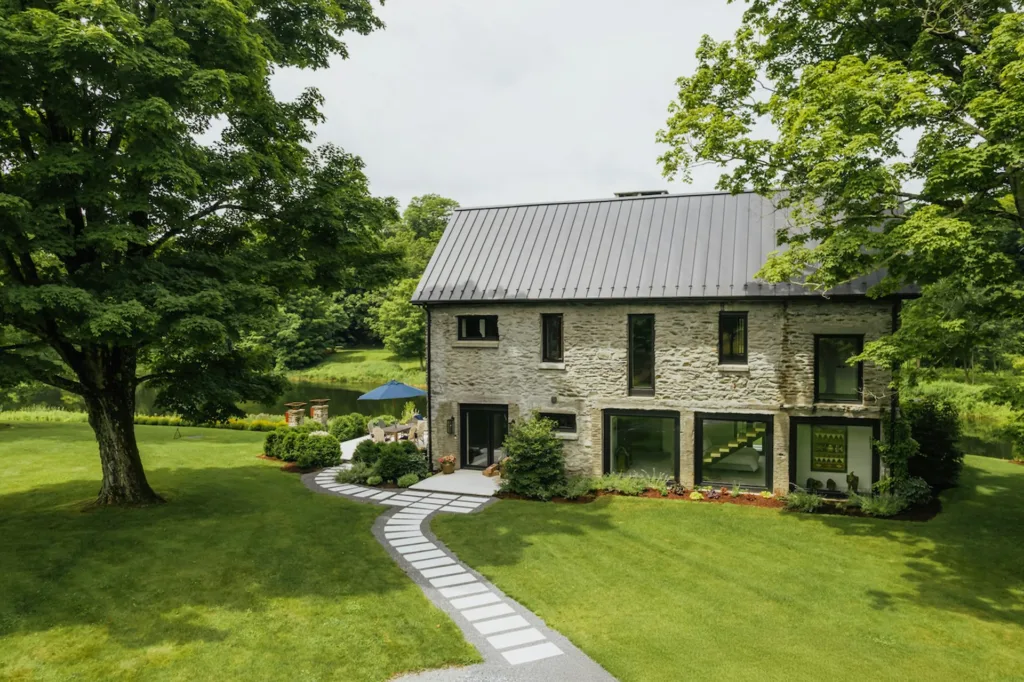 an iimage of a stone house with modern windows and roof