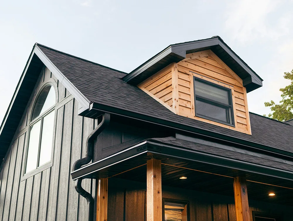 an image of a traditional house with natural wood siding on the dormer and natural wood posts and beam