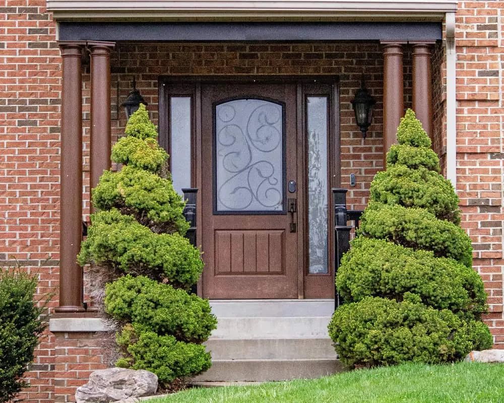 a faux wood fiberglass front entry door on a brick veneer home