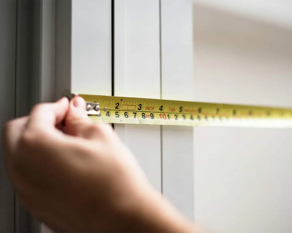 using a tape measure to measure for a new front entry door