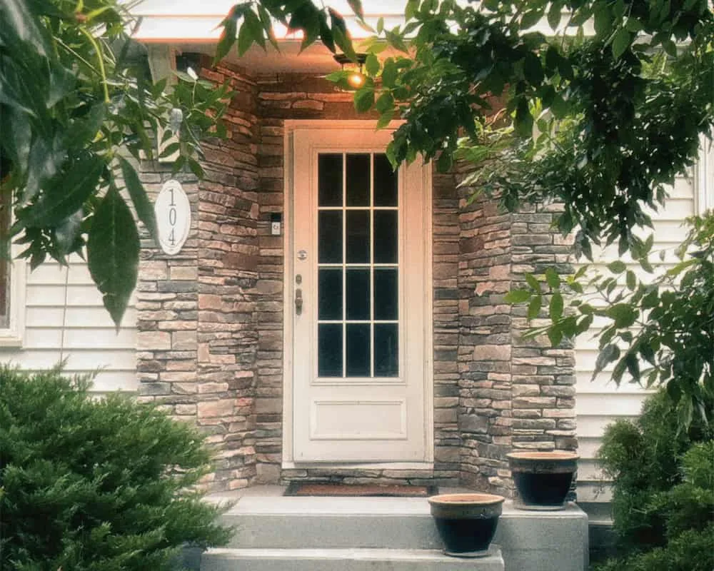 a steel front entry door on a house with stone siding